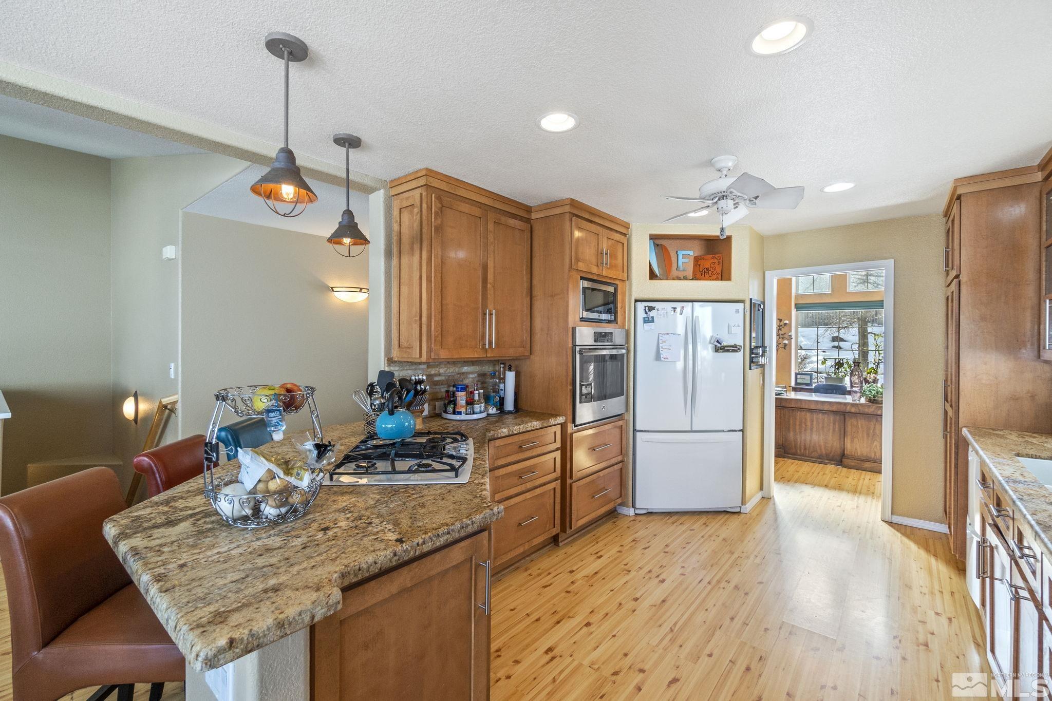 6075 Sunrise Meadows Loop Reno, NV 89519 - Photo 7 of 38 a kitchen with stainless steel appliances granite countertop a refrigerator a oven a sink and a counter