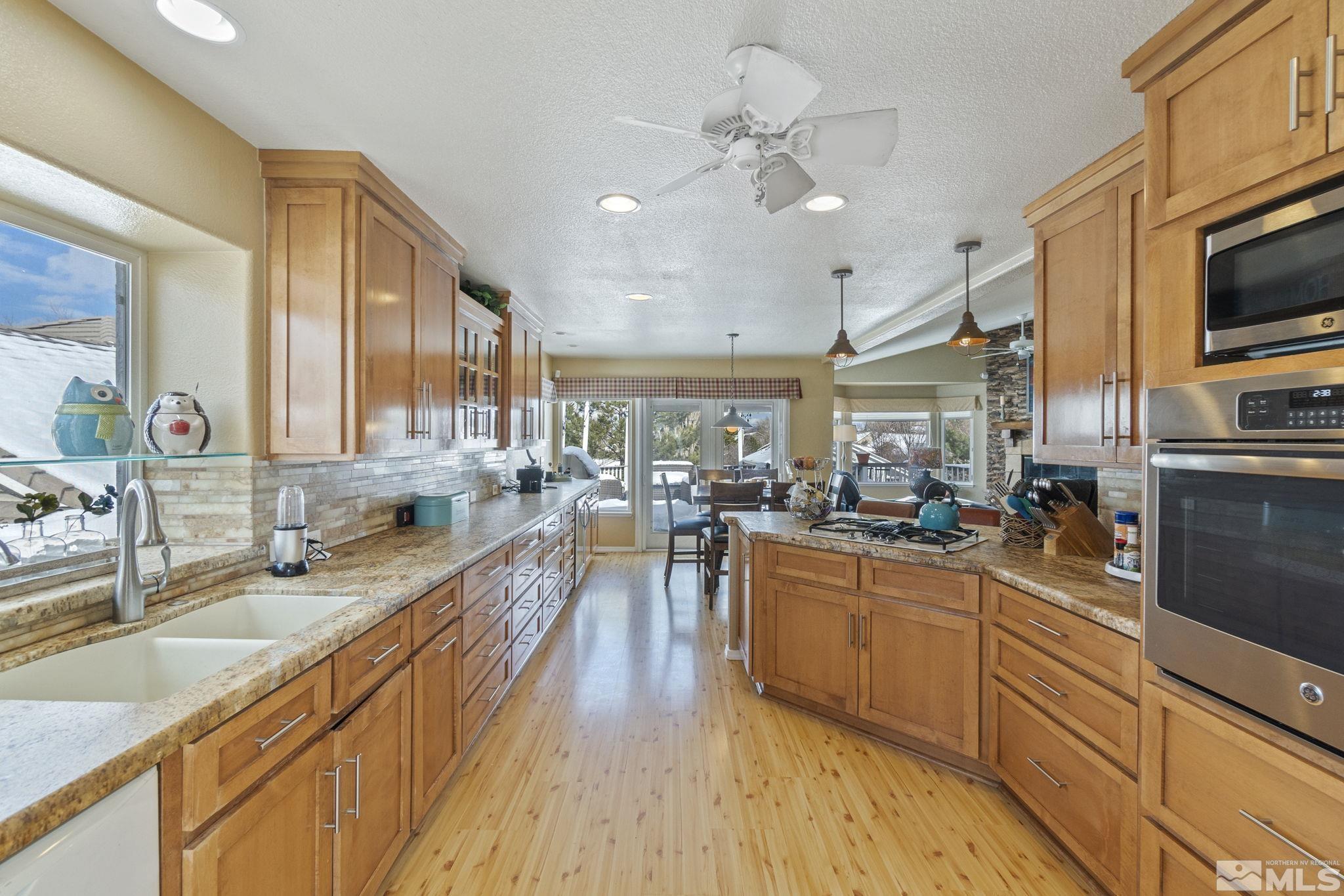 6075 Sunrise Meadows Loop Reno, NV 89519 - Photo 8 of 38 a large kitchen with stainless steel appliances granite countertop a lot of counter space and wooden floors
