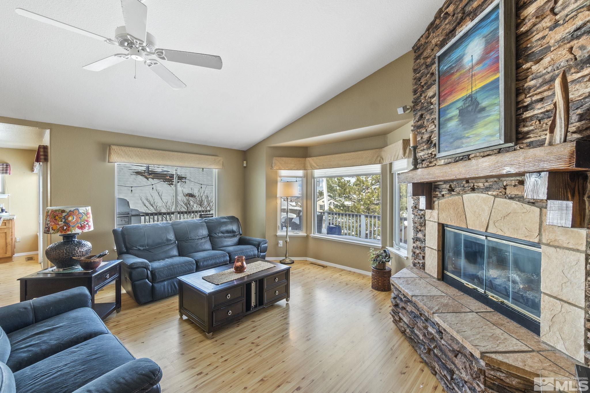 6075 Sunrise Meadows Loop Reno, NV 89519 - Photo 9 of 38 a living room with furniture a fireplace and a large window