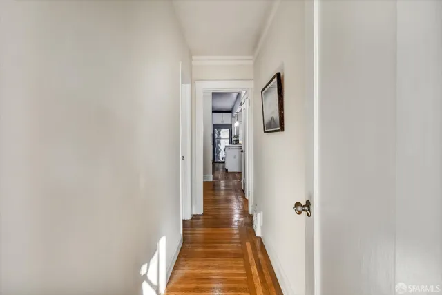 a view of a hallway with wooden floor