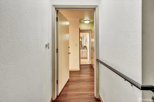 a kitchen with stainless steel appliances a refrigerator and a wooden floor