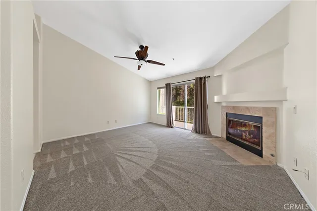a view of an empty room with window and fireplace