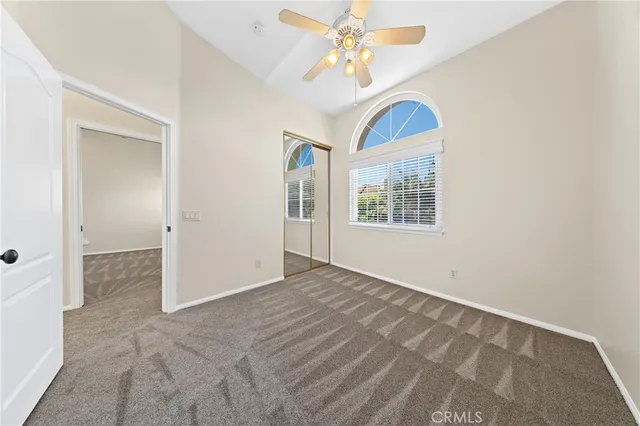 an empty room with windows and fan