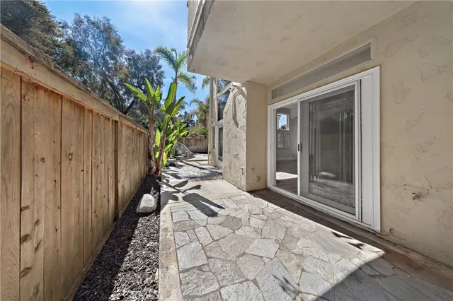 a porch with wooden floor and a potted plant