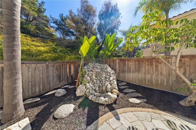 a view of a backyard with plants and tree