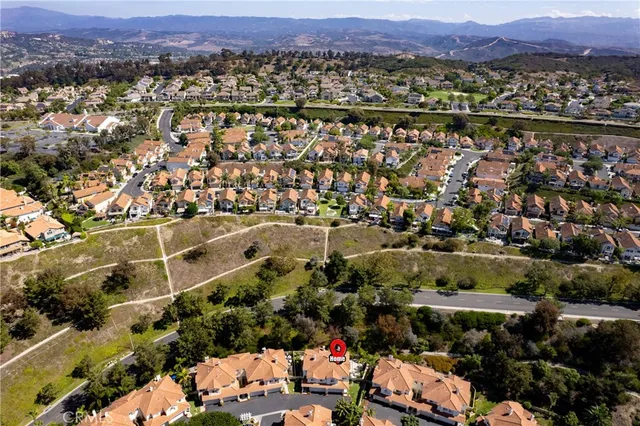 an aerial view of a city with lots of residential buildings and mountain view in back