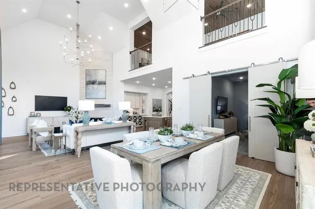 a view of a dining room with furniture a rug and wooden floor