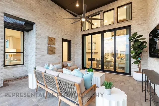 a living room with furniture large windows and wooden floor