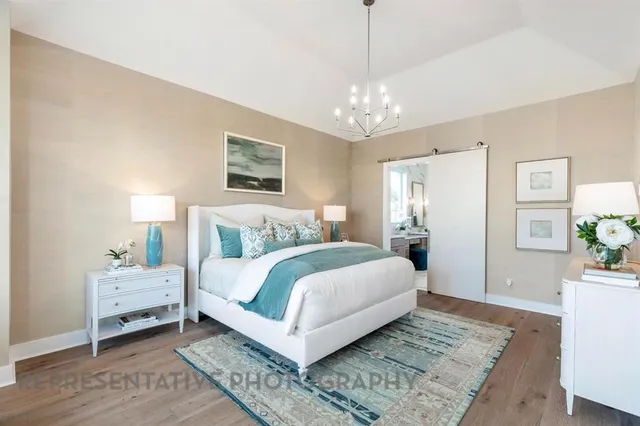 a spacious bedroom with a large bed and a chandelier