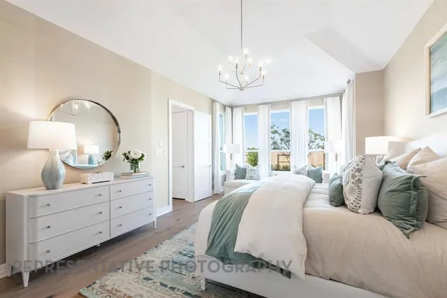 a spacious bedroom with a bed and dresser with mirror