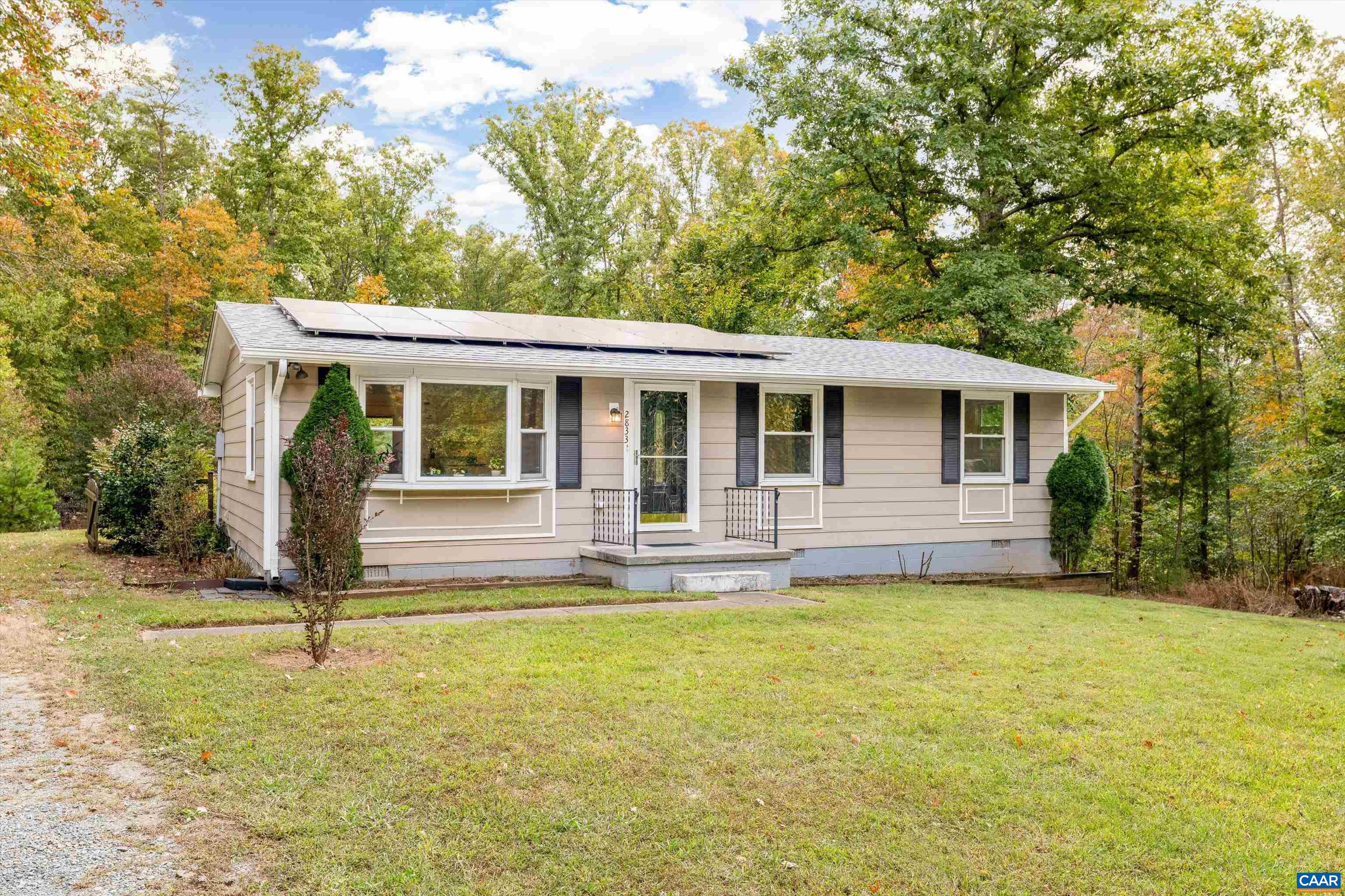 a view of a house with backyard and a tree