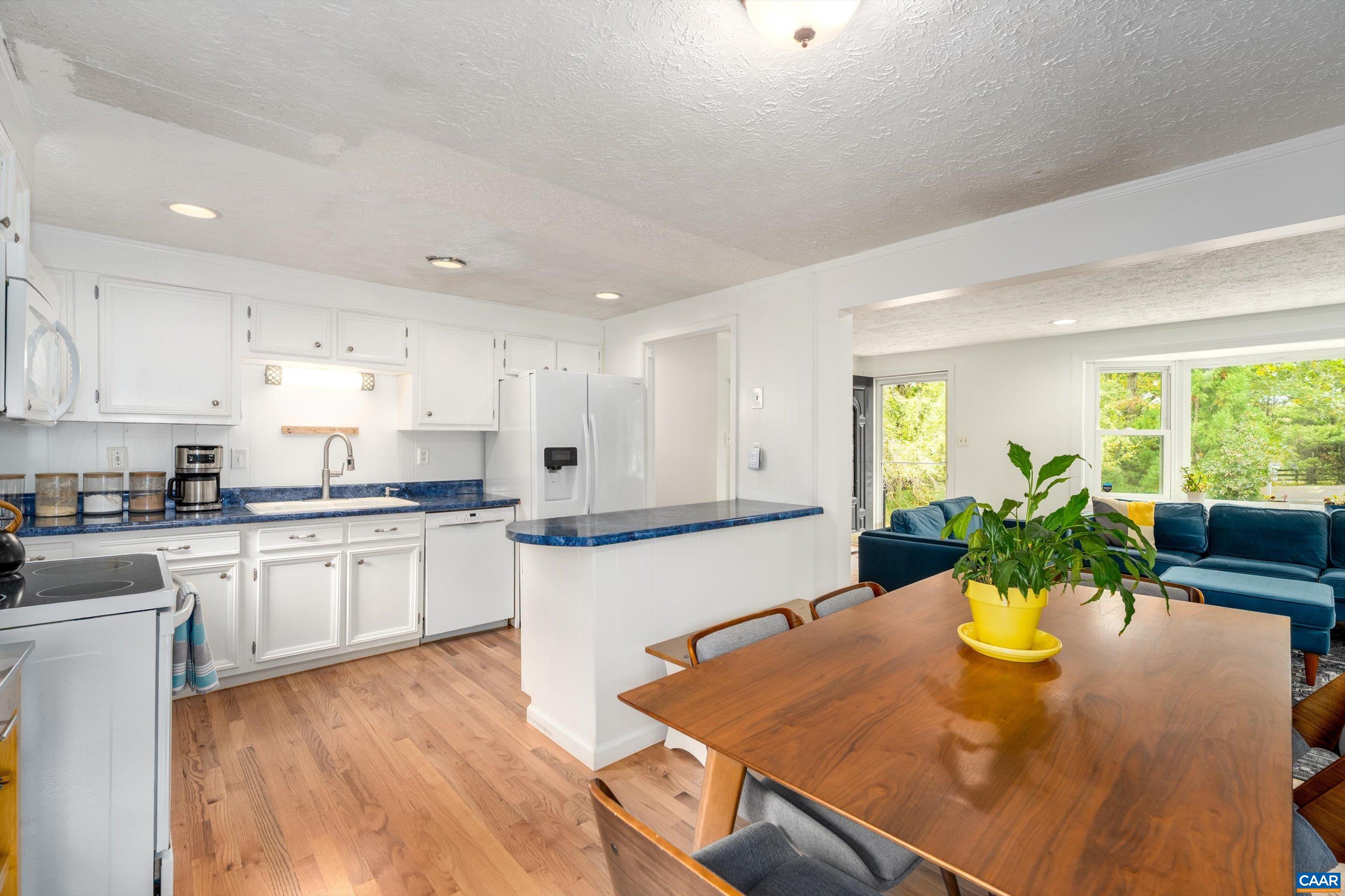 2833 Milton Road Charlottesville, VA 22902 - Photo 4 of 44 a kitchen with stainless steel appliances granite countertop sink stove and white cabinets with wooden floor
