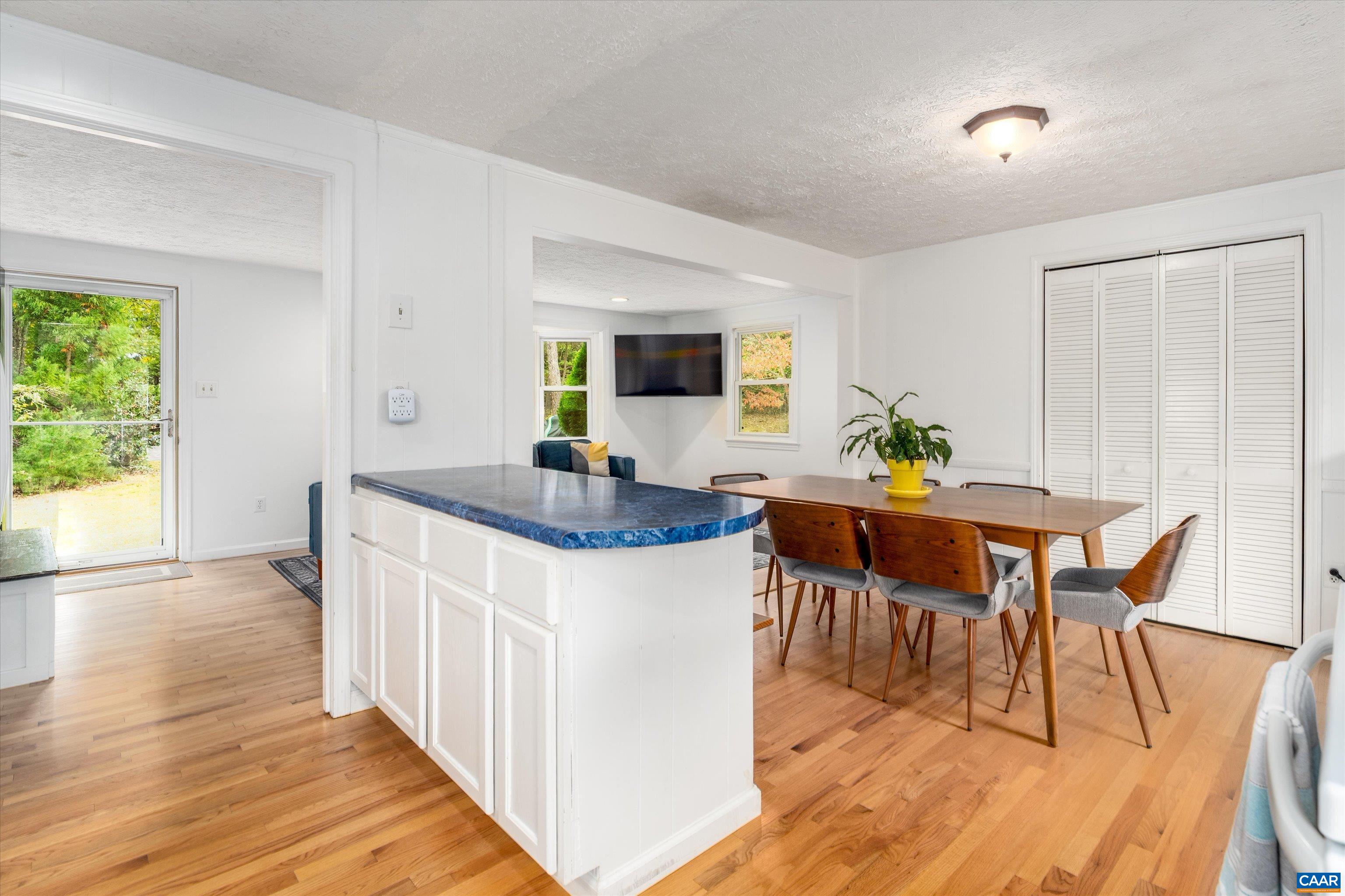 2833 Milton Road Charlottesville, VA 22902 - Photo 5 of 44 a kitchen with stainless steel appliances granite countertop wooden floor a dining table and chairs