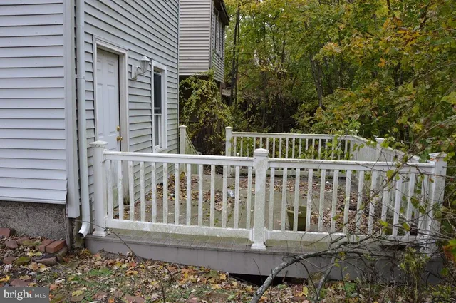 a porch with a bench next to a yard