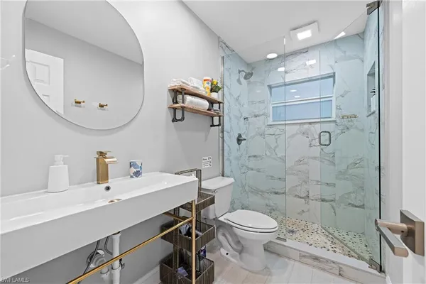 a bathroom with a sink a toilet and shower