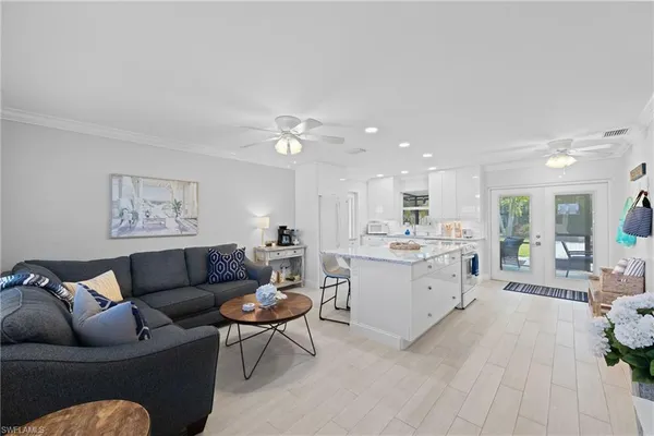 a living room with furniture and view of kitchen