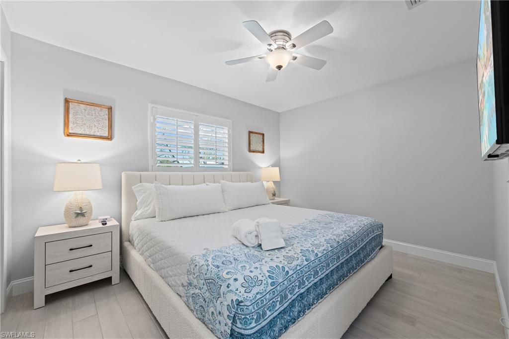 732 108th Avenue North Naples, FL 34108 - Photo 8 of 28 a bedroom with a bed and a chandelier