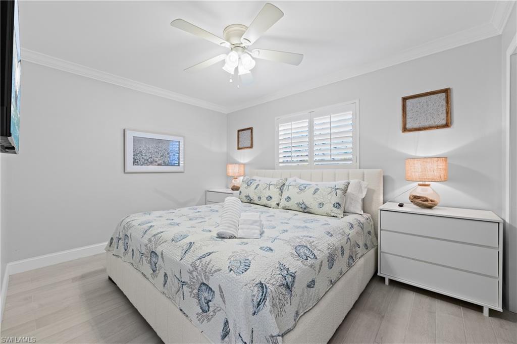 732 108th Avenue North Naples, FL 34108 - Photo 10 of 28 a bedroom with a bed and a chandelier