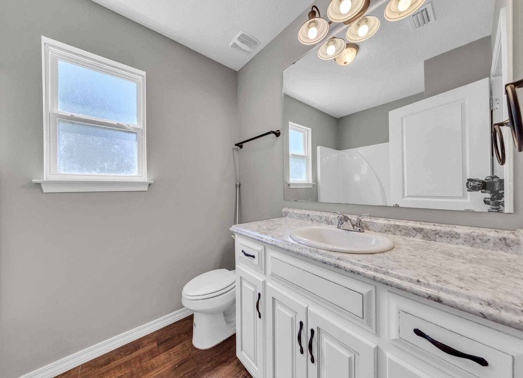 129 Fairway Drive Crestview, FL 32536 - Photo 13 of 30 a bathroom with a granite countertop sink a toilet and a mirror