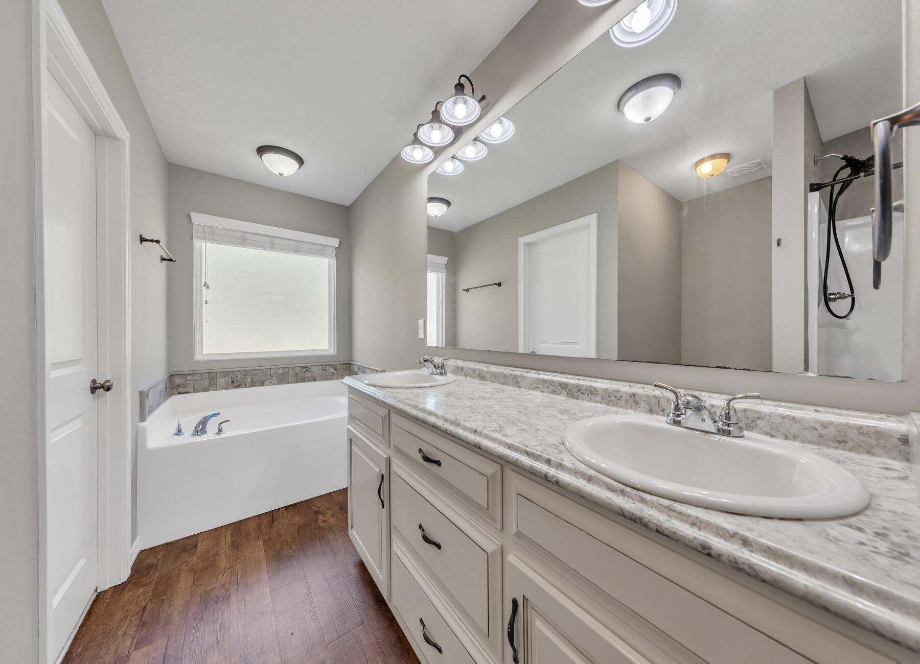 129 Fairway Drive Crestview, FL 32536 - Photo 16 of 30 a bathroom with a granite countertop sink a large mirror and a bathtub