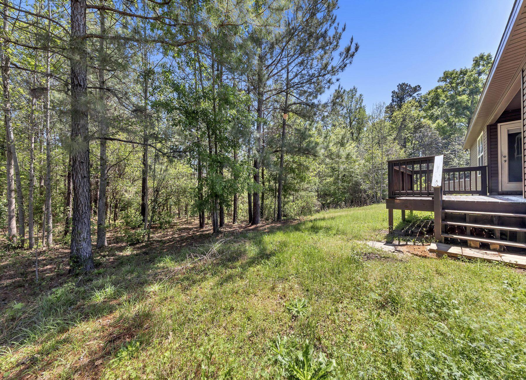 129 Fairway Drive Crestview, FL 32536 - Photo 27 of 30 a view of a backyard with wooden fence and a large tree