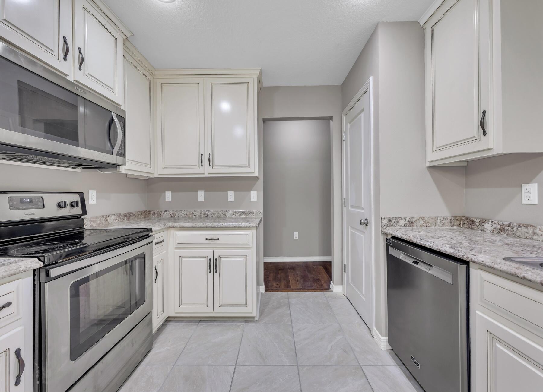 129 Fairway Drive Crestview, FL 32536 - Photo 9 of 30 a kitchen with stainless steel appliances granite countertop a stove top oven microwave and cabinets