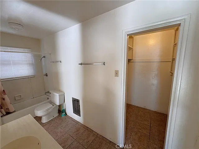 a bathroom with a granite countertop shower and a toilet