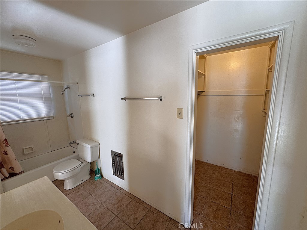 521 East Williams Street Barstow, CA 92311 - Photo 20 of 25 a bathroom with a granite countertop shower and a toilet