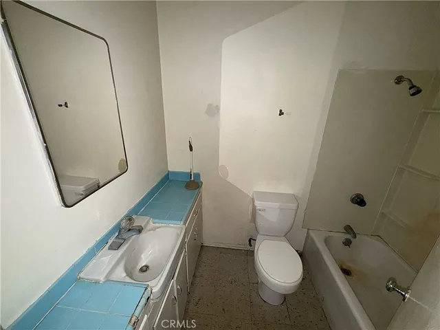 a bathroom with a granite countertop toilet sink and mirror