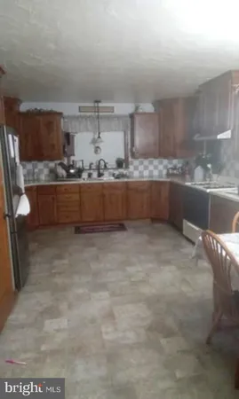 a large kitchen with kitchen island a sink stainless steel appliances and cabinets