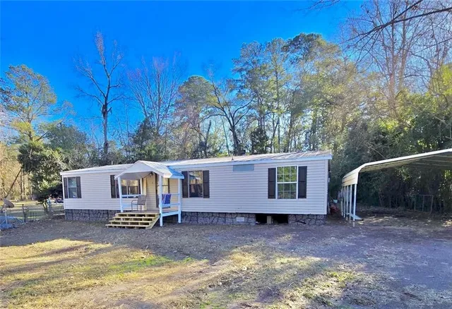 a view of a house with backyard and sitting area