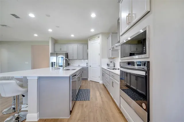 a kitchen with a sink stainless steel appliances and cabinets