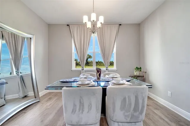 a dining room with table chairs and chandelier