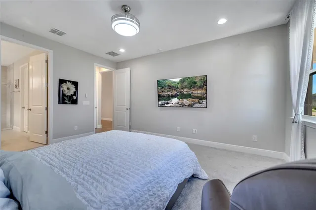 a bedroom with a large bed and a chandelier