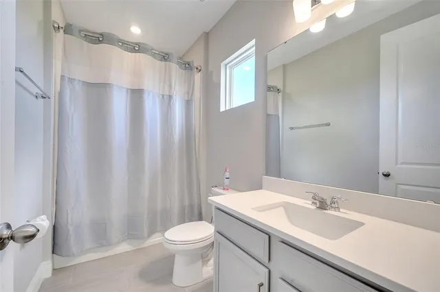 a bathroom with a sink a toilet and shower curtain