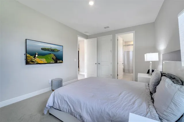 a bedroom with a bed and painting on the wall