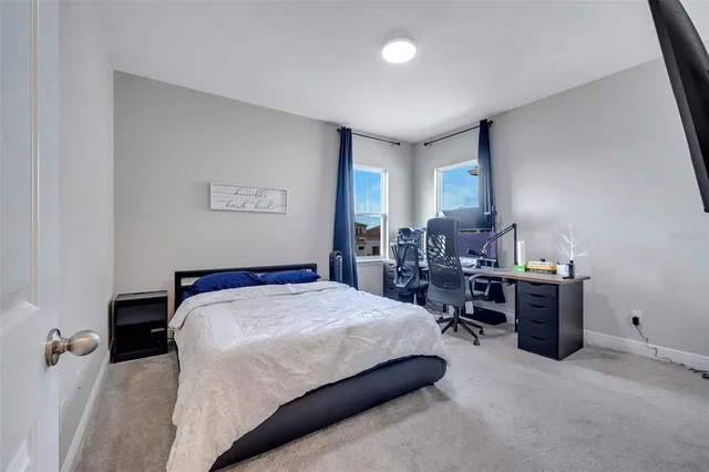 a bedroom with a bed window and a chair