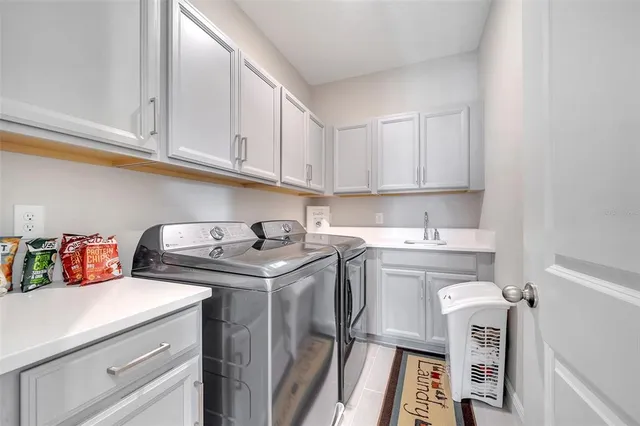 a utility room with sink dryer and washer