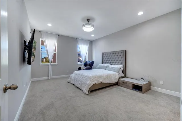 a spacious bedroom with a bed and a lamp with the bathroom