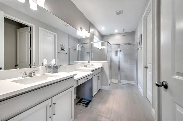 a bathroom with a double vanity sink a mirror and a shower