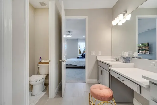 a spacious bathroom with a granite countertop sink a toilet and a large mirror