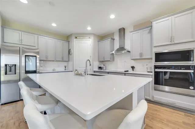 a large white kitchen with white stainless steel appliances and white cabinets