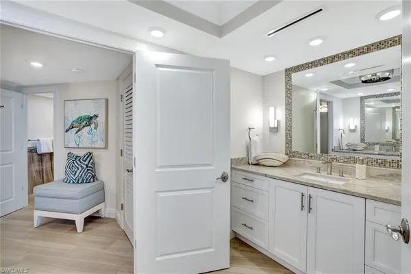 a spacious bathroom with a granite countertop sink and a mirror