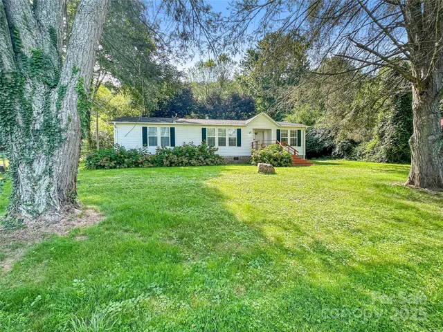 a front view of a house with yard and green space