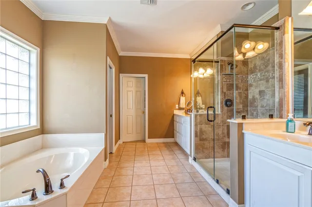 a bathroom with a tub a mirror and a shower