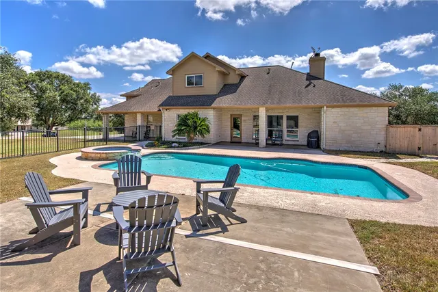 a view of a house with swimming pool and sitting area