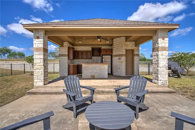 a view of a patio with table and chairs with wooden floor and fence