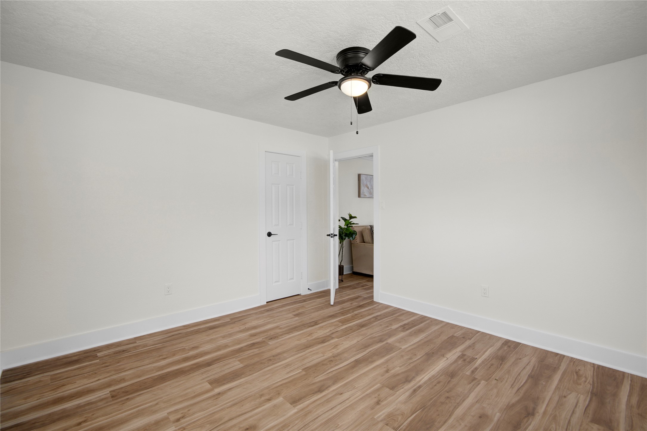 4909 Cochran Street, Unit 12 Houston, TX 77009 - Photo 16 of 29 an empty room with wooden floor and ceiling fan