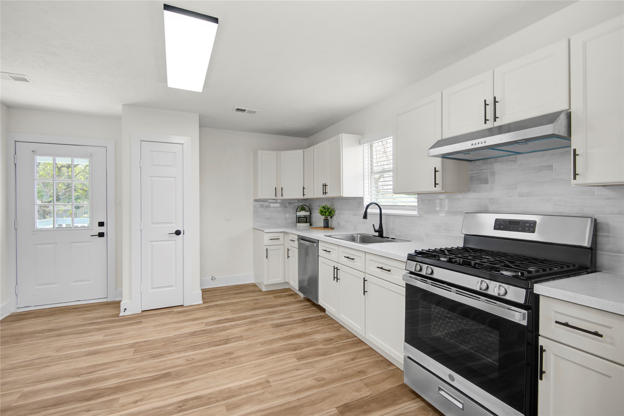 4909 Cochran Street, Unit 12 Houston, TX 77009 - Photo 10 of 29 a kitchen with stainless steel appliances white cabinets and stove