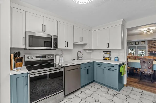 a kitchen with a sink and steel appliances